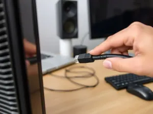Nowoczesna drukarka 3D w trakcie pracy, precyzyjnie nakładająca warstwę filamentu na czystym biurku w jasnym biurze.